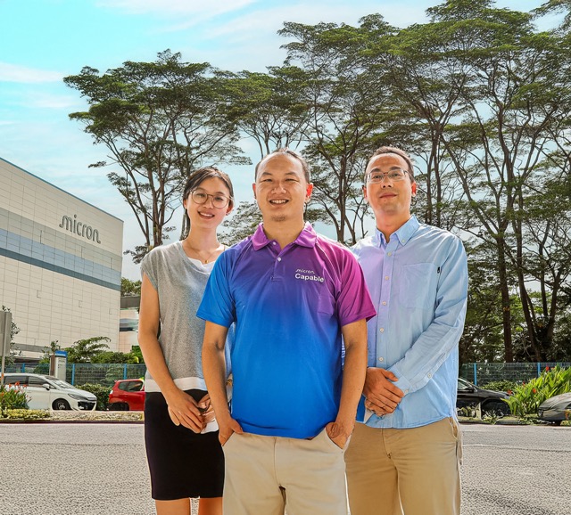 Award-recipient employees standing proudly outside their office
